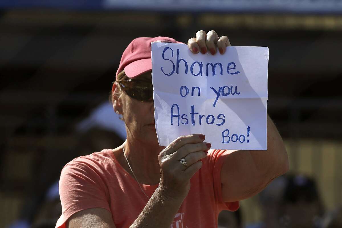 A fan holds a sign a spring training baseball game between the Houston Astros and the Washington Nationals Sunday, Feb. 23, 2020, in West Palm Beach, Fla. (AP Photo/John Bazemore)