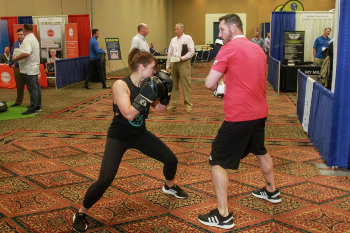 Andrew Scott, co-founder and national head coach for Legends Boxing, during a demonstration with his wife, Kelly, at the Great American Franchise Expo in Stafford on February 23, 2020. Kelly is hitting Andrew's focus gloves.