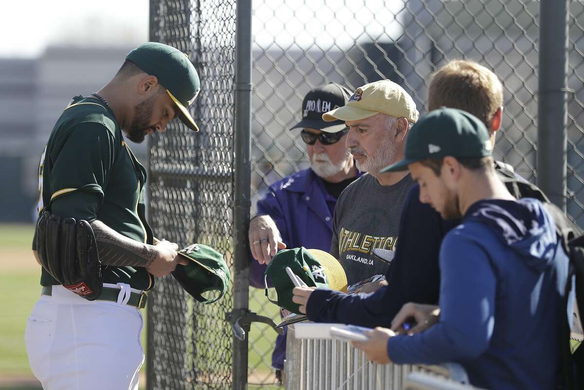 Oakland Athletics' Sean Manaea signs autographs for fans during spring training baseball practice, Thursday, Feb. 20, 2020, in Mesa, Ariz. (AP Photo/Darron Cummings)