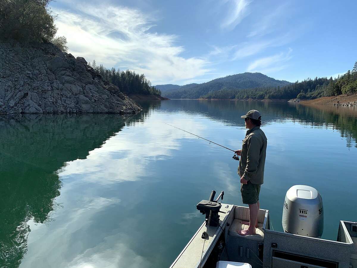 Jeremy Keyston casts for bass at Shasta Lake, where warm, calm days have felt like spring, the picture this week at many lakes in California