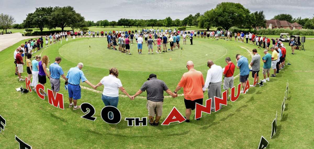 Players pray before last year's golf tournament benefiting Katy Christian Ministries.