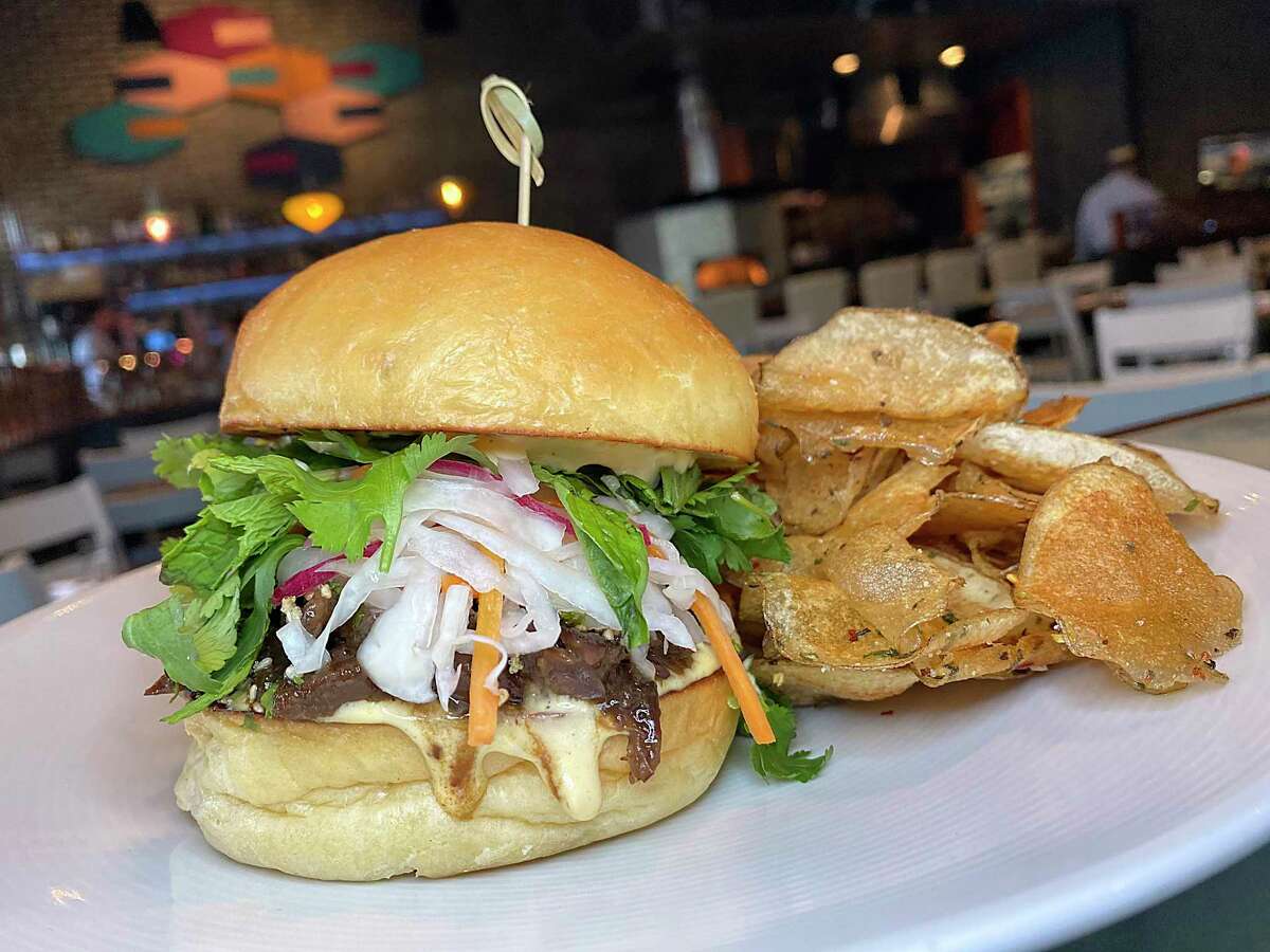 The Far Eastsider sandwich incorporates bulgogi-style beef cheeks, vinegar slaw, herb salad and golden beet aioli on a housemade bun with freshly made potato chips at Full Belly Cafe and Bar.