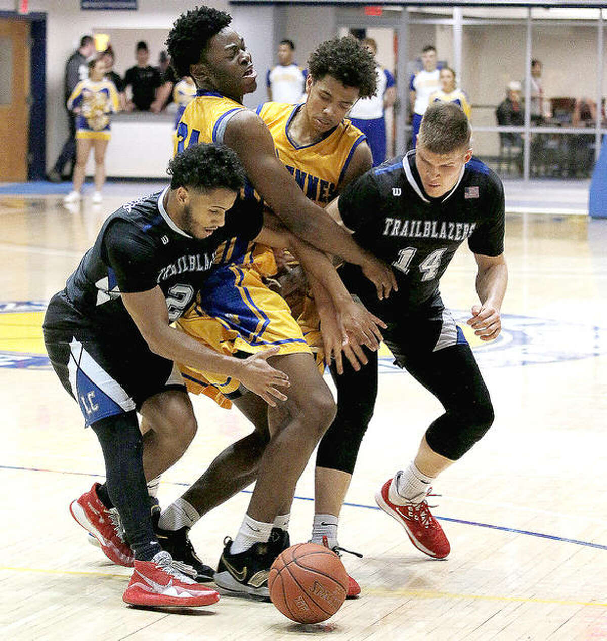 Vincennes University’s Chinedu Okanu and Craig Porter, middle, along with Lewis and Clark’s Ulysses Delayney, left, and Amandas Urkis (14) charge after a loose ball Monday night at Vincennes.