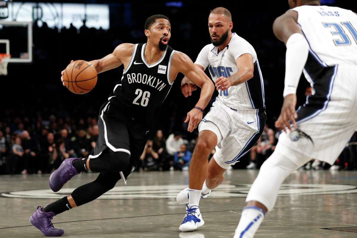 Brooklyn Nets guard Spencer Dinwiddie (26) drives around Orlando Magic guard Evan Fournier (10) during the first half of an NBA basketball game Monday, Feb. 24, 2020, in New York. Magic guard Terrence Ross (31)watches. (AP Photo/Kathy Willens)