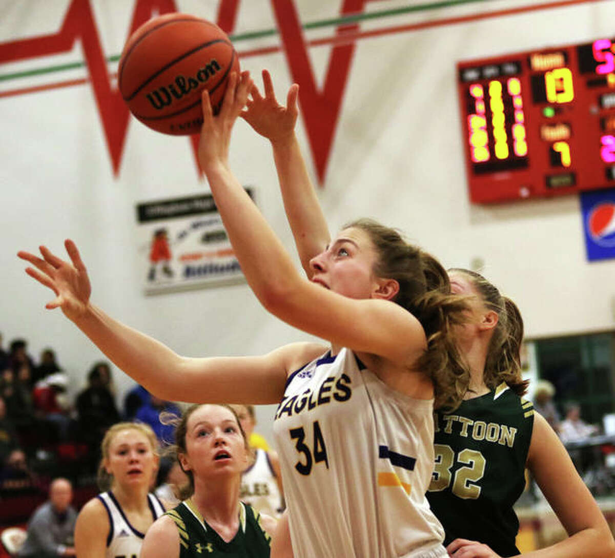 CM’s Jackie Woelfel (34) beats Mattoon’s Hallie Niemerg to the basket for two points in the third quarter Monday night at the Effingham Class 3A Sectional.