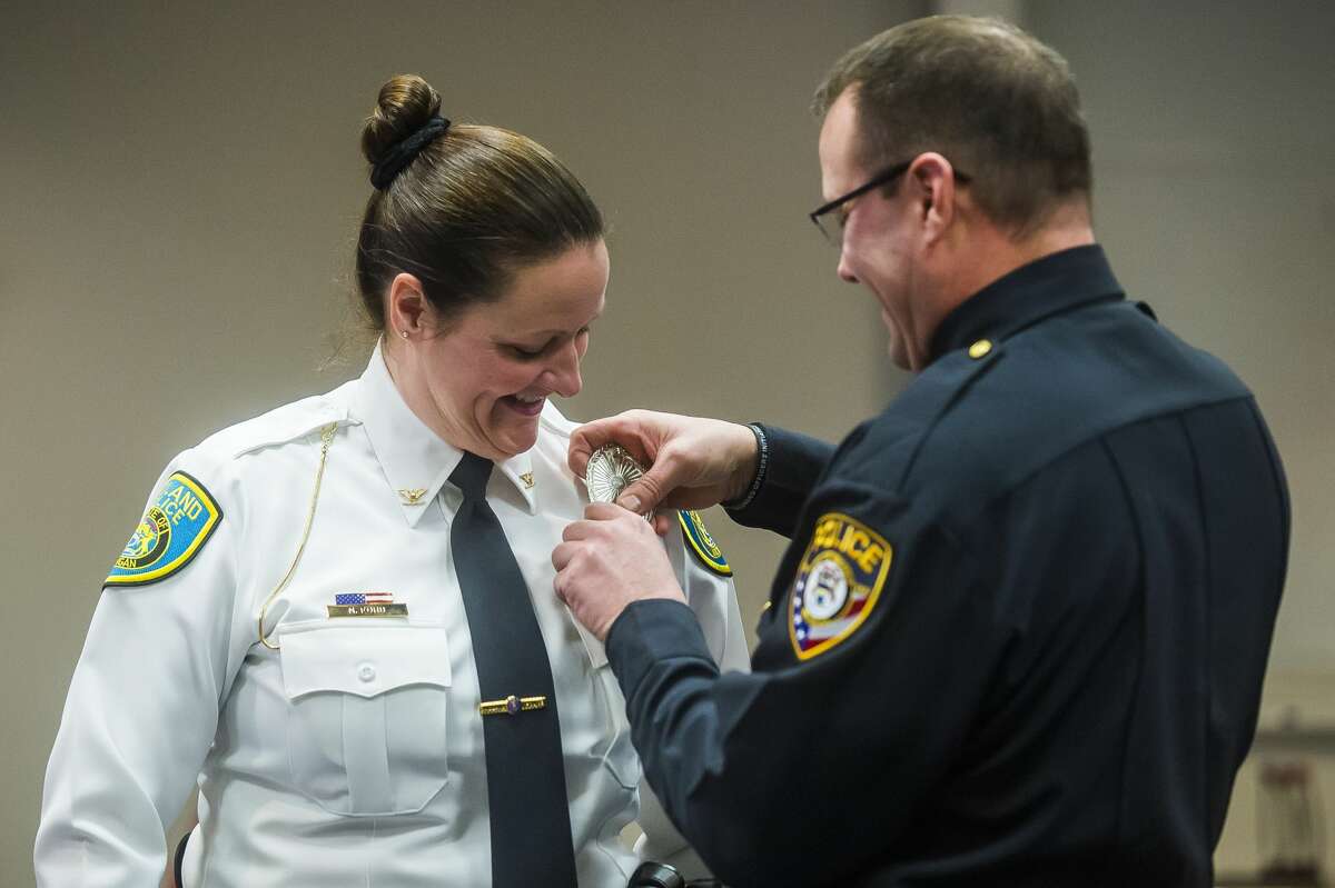Lt. Jeffrey Smith of the Inkster Police Department pins a badge onto the uniform of his wife, City of Midland Police Chief Nicole Ford, during her swearing-in ceremony Monday, Feb. 24, 2020 at City Hall. Ford is the first woman to serve as Police Chief in Midland. (Katy Kildee/kkildee@mdn.net)