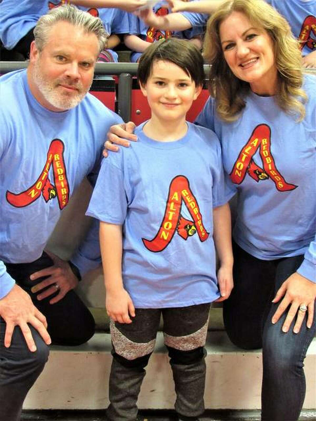 Vedder Obermeyer, along with his parents, Lance and Michelle Obermeyer, poses with the shirt he designed last year.