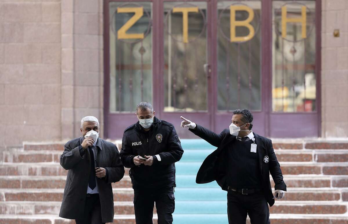 Security officials walk at the entrance of Zekai Tahir Burak Hospital where 17 passengers of a Turkish Airlines flight from Tehran, suspected of having coronavirus, were to be quarantined, in Ankara, Turkey, Tuesday, Feb. 25, 2020. All 132 passengers of Tehran-Istanbul flight and crew on board will be quarantined for 14 days at the same hospital where Turkish citizens returning from China had been quarantined.( AP Photo/Burhan Ozbilici)