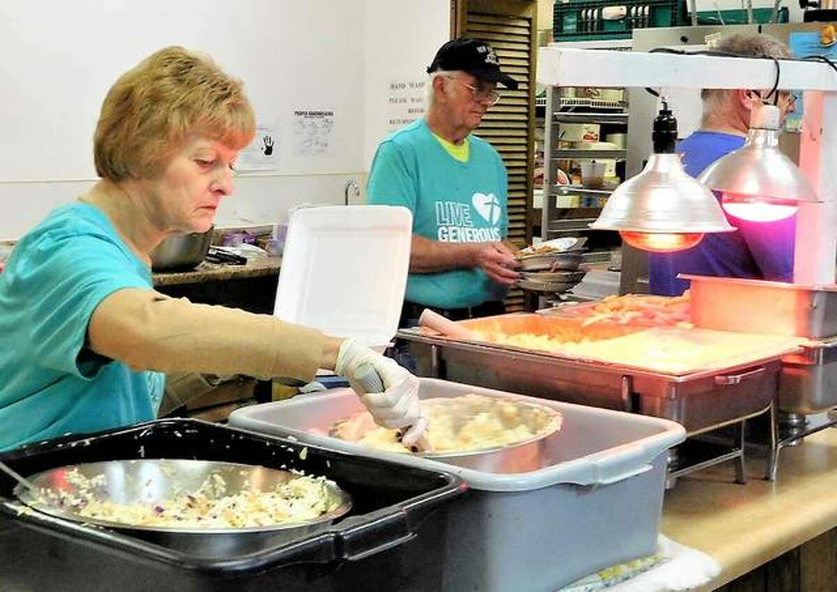 Holy Cross Lutheran Church members serve up fish dinners last year. Weekly attendance at the church is about 50, but it sees more than six times as many people at its Friday fish fries during Lent.