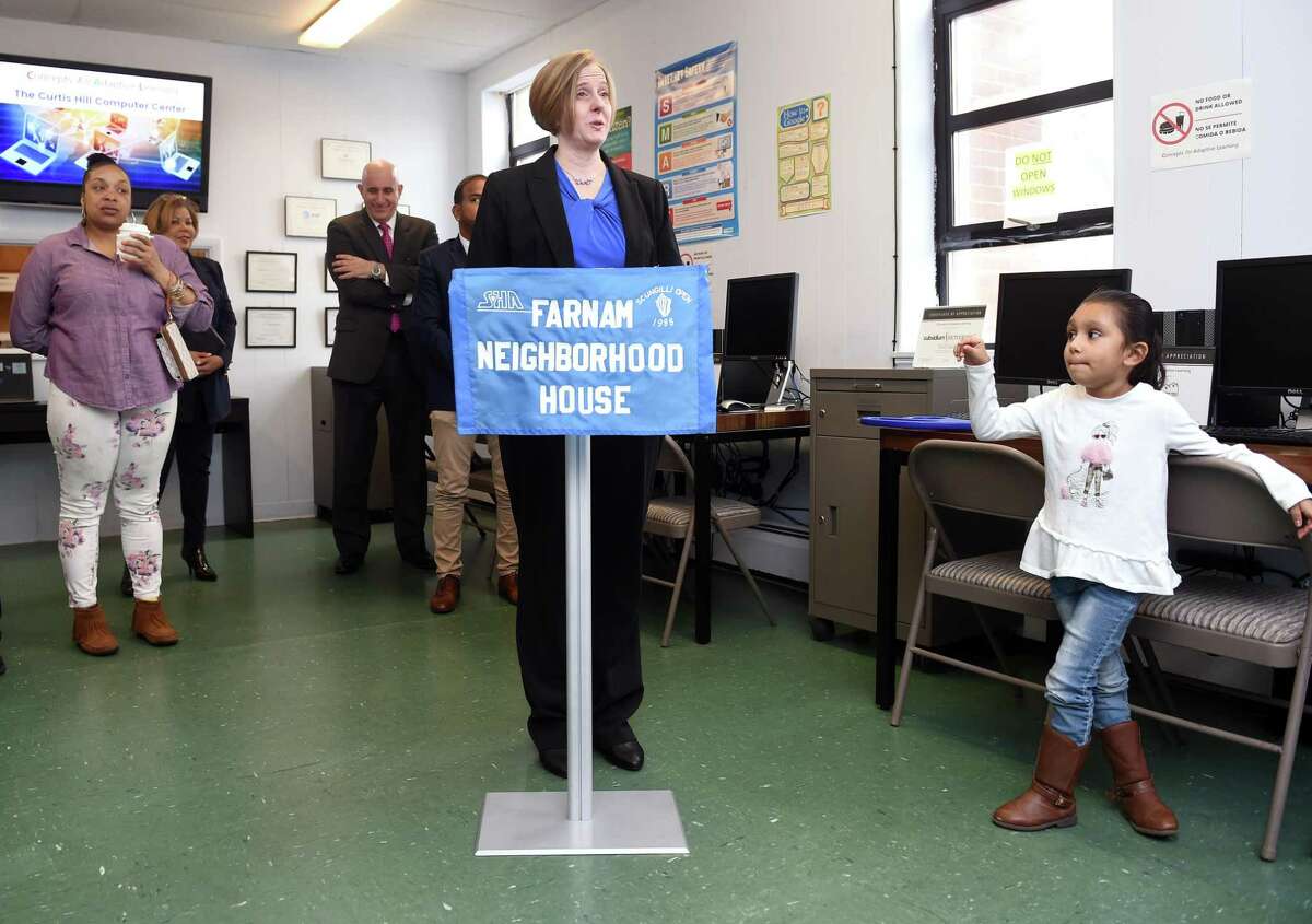 Preschooler Sophia Ortiz (right), 5, listens to Jennifer Ricker, Executive Director of Concepts for Adaptive Learning, speak at a ribbon cutting ceremony for the Curtis Hill Computer Center at the Farnam Neighborhood House in New Haven on February 25, 2020. Adults are given a computer after completing a six-week computer class at the Farnam Neighborhood House which partners with Concepts for Adaptive Learning. About 10 people per month compete the program at this location.