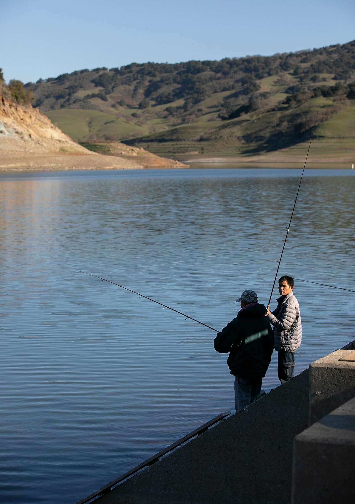From right, Jiang and Hang of Morgan Hill, fish at Anderson Lake Reservoir on Tuesday, Feb. 25, 2020 in Morgan Hill, Calif.