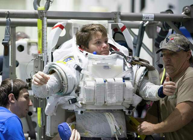 Suit Engineer Wesley Wilson, left, and Suit Technician Don Smith help astronaut Anne McClain to suit up for spacewalk training at NASA’s Neutral Buoyancy Laboratory on Tuesday, Feb. 25, 2020, in Houston.