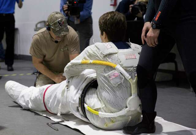 Suit Technician Don Smith helps astronaut Anne McClain get into the lower part of her spacesuit for spacewalk training at the Neutral Buoyancy Laboratory on Tuesday, Feb. 25, 2020, in Houston.