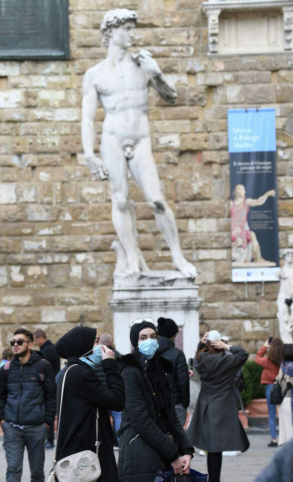Tourists with protective masks visit Florence on Feb. 25, 2020 as Tuscany reported its first two cases of COVID-19.