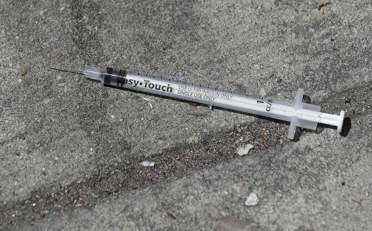 In this file photo from Thursday, May 10, 2018, a used syringe is shown on a sidewalk in San Francisco.