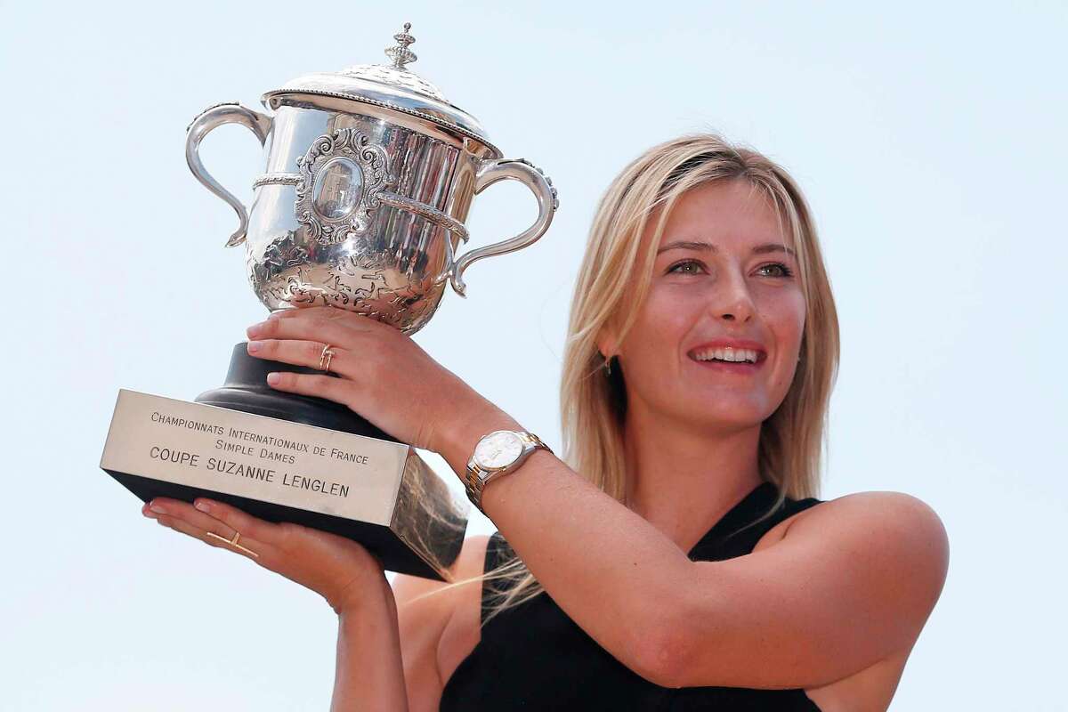 (FILES) In this file photo taken on June 8, 2014, Russia's Maria Sharapova poses with the Suzanne Lenglen trophy in a day after winning the Roland Garros French Tennis Open. - Five-time Grand Slam winner Maria Sharapova, one of the world's most recognisable sportswomen, on February 26, 2020, announced her retirement from tennis. "Tennis I'm saying goodbye," Sharapova said in an article for Vogue and Vanity Fair magazines. "After 28 years and five Grand Slam titles, though, I'm ready to scale another mountain to compete on a different type of terrain." (Photo by Kenzo TRIBOUILLARD / AFP)