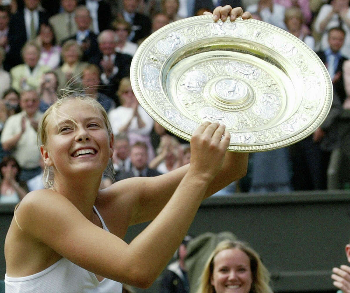 FILE - In this July 3, 2004, file photo, Russia's Maria Sharapova holds the winner's trophy after defeating Serena Williams in the Women's Singles final match on the Centre Court at Wimbledon. Sharapova is retiring from professional tennis at the age of 32 after five Grand Slam titles and time ranked No. 1. She has been dealing with shoulder problems for years. In an essay written for Vanity Fair and Vogue about her decision to walk away from the sport, posted online Wednesday, Feb. 26, 2020, Sharapova asks: “How do you leave behind the only life you’ve ever known?” (AP Photo/Anja Niedringhaus, File)