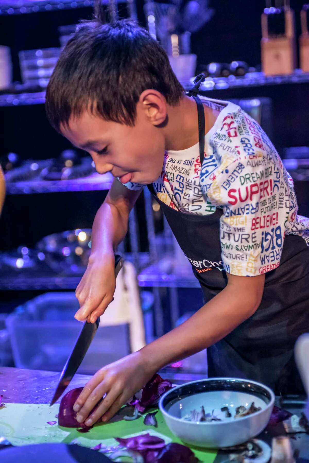 A young cook slices an onion in “MasterChef Jr. Live!”