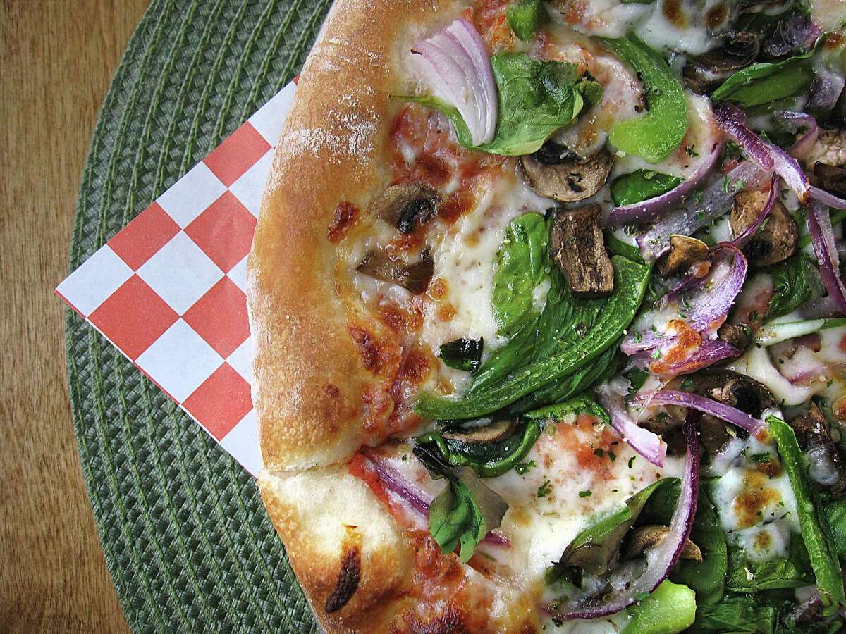 Pizza choices include a veggie pizza with spinach, mushrooms, tomatoes, bell pepper and onions at Royal Pizza.