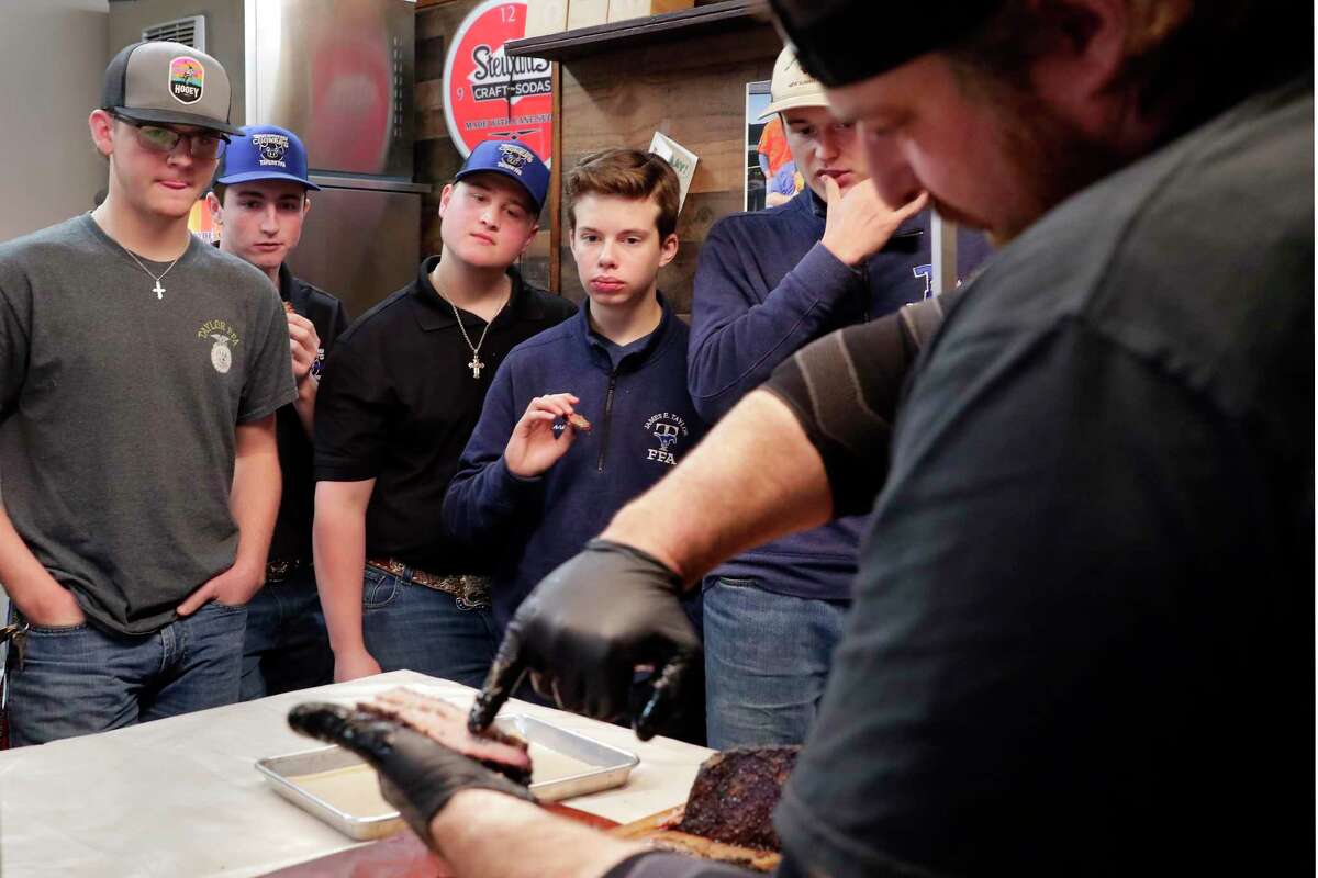 Pitmaster Brett Jackson, right, describes what to look for in a slice of brisket as students from James E. Taylor High School’s barbecue team in Katy listen during a visit to Jackson’s restaurant, Brett’s Barbecue Shop in Katy.