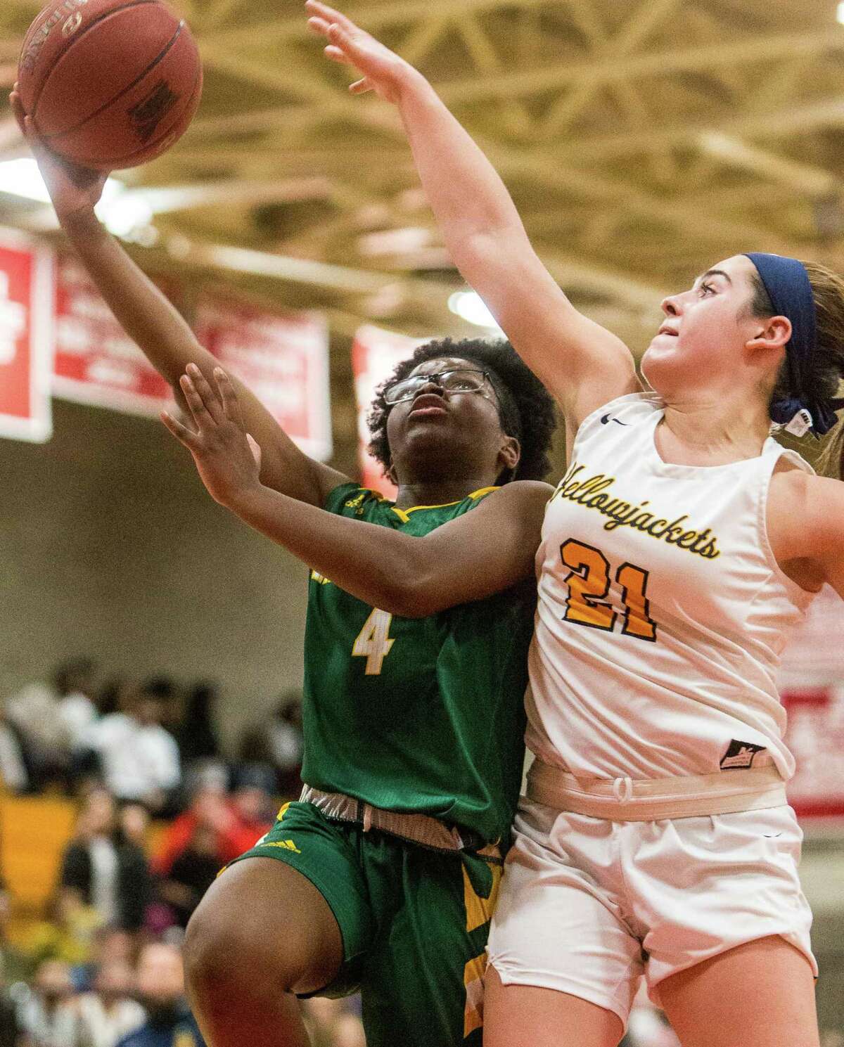 Hamden’s Diamond White Goes up for a layup as East Haven’s Isabella Ragaini goes for the block during the SCC championship game on Wednesday.