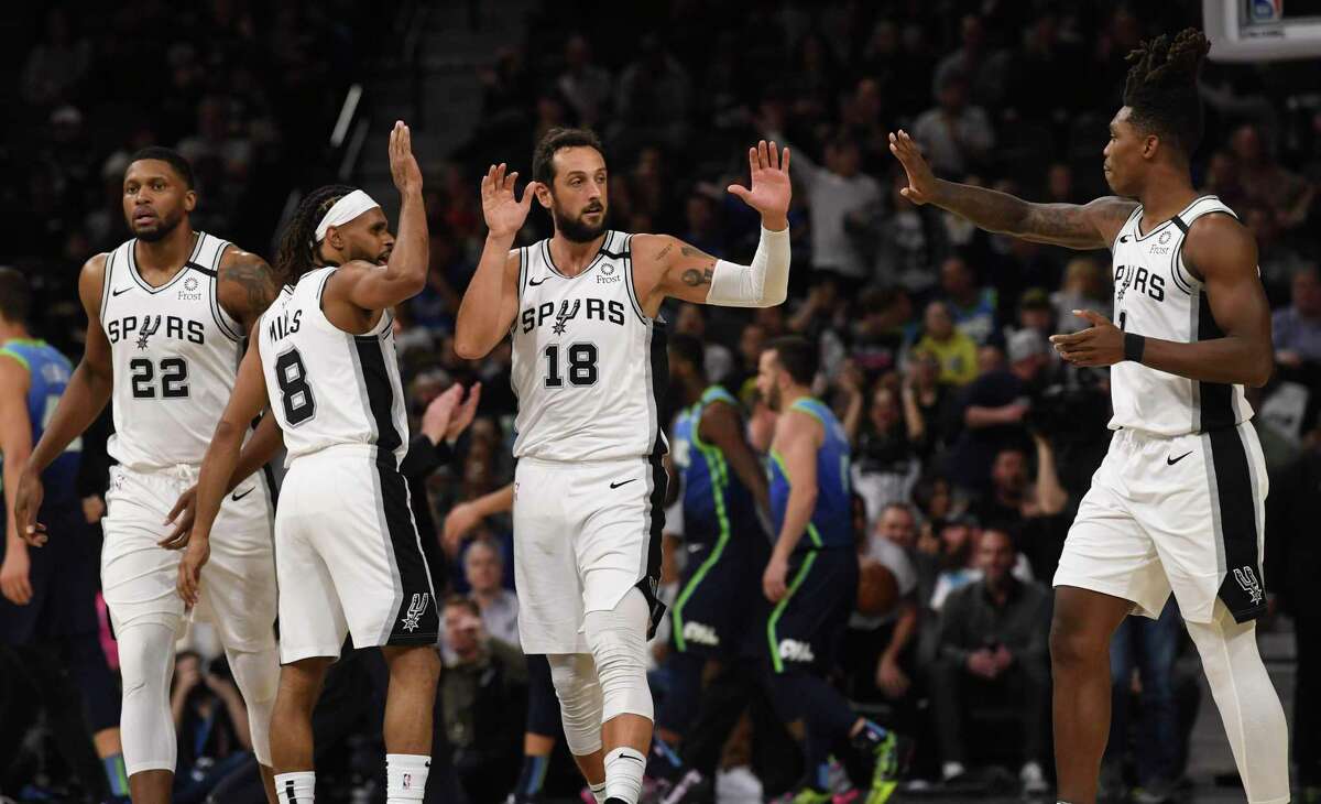 Marco Belinelli (18) of the San Antonio Spurs is congratulated by teammates Lonnie Walker IV, right, Rudy Gay (22) and Patty Mills (8) during second-half NBA action in the AT&T Center on Wednesday, Feb. 26, 2020.