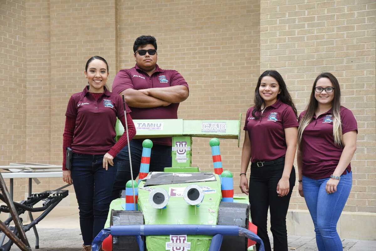 The Dusty Motors team stands next to a cardboard version of, Toy Story's RC during the Discover TAMIU Event at TAMIU, Saturday, April 7, 2018.