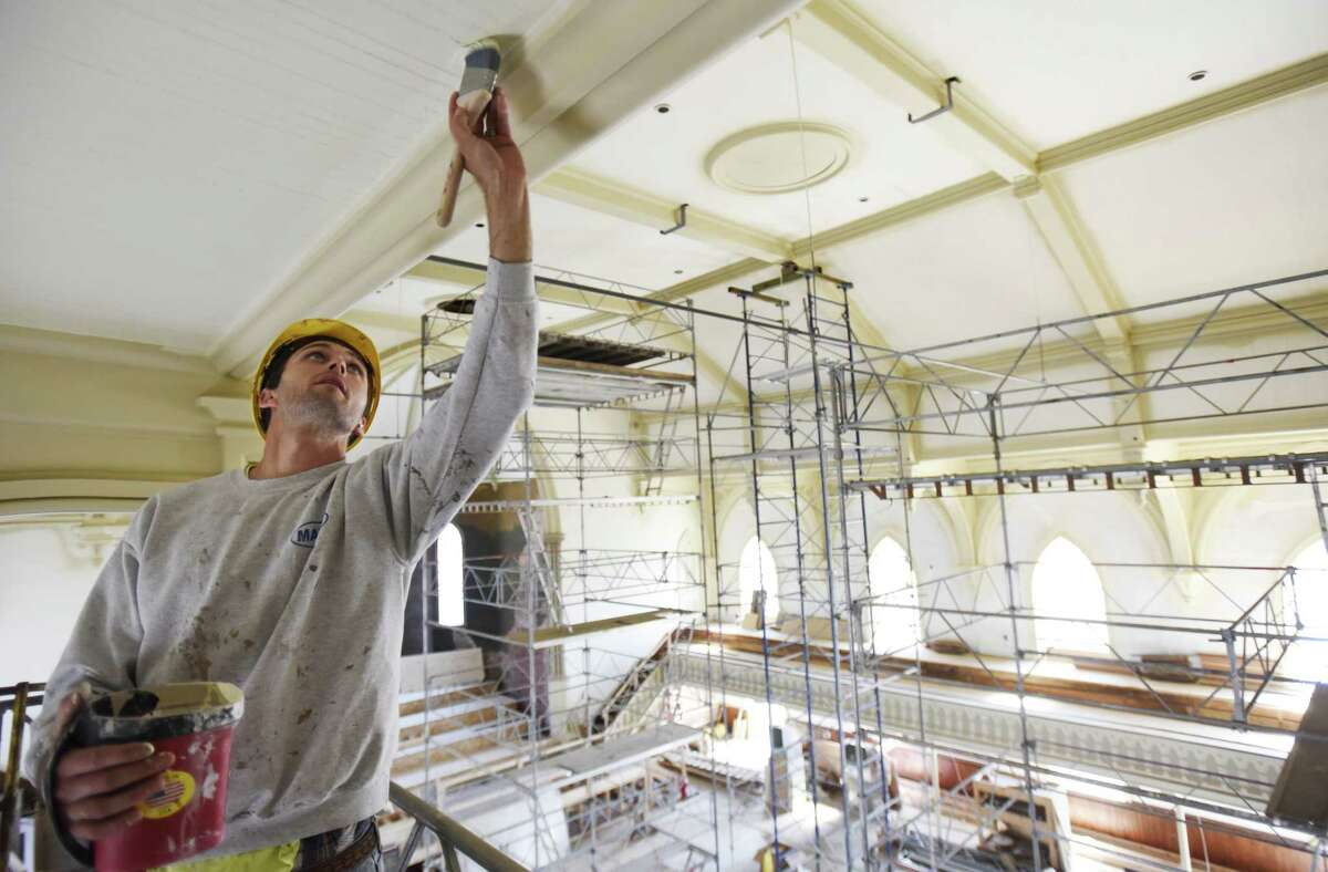 A construction worker touches up pain on the ceiling in the great hall at UPH in Saratoga Tuesday, June 4, 2019. (Photo courtesy UPH/Proctors.)