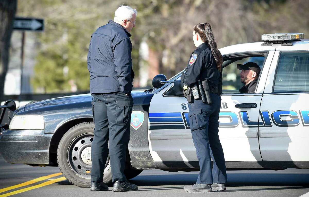 Stamford Acting Police Chief Tom Wuennemann, left, talks with officers standing by at a road block on Newfield Avenue near Trinity Catholic High School in Stamford, Conn. on Feb. 27, 2020. Reports of an incident involving an active shooter at a nearby residential home drew a heavy police presence, causing the high school to shelter in place. The initial call was determined to be a hoax, police said.