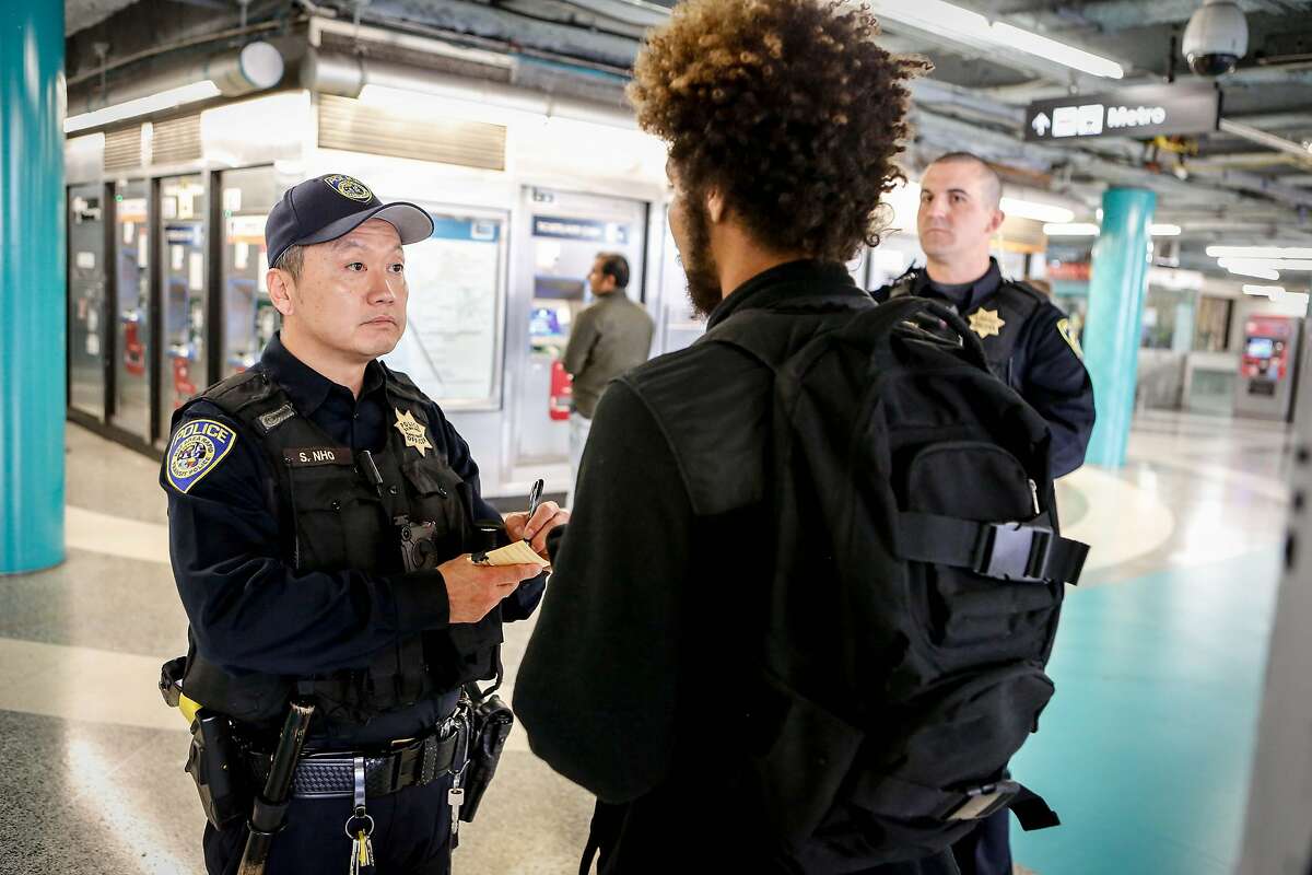 Police officers (L to R) S. Nho and M. Campbell take Jordyn Christo's information and issue him a warning at Powell Station BART entrance after Christo was caught jumping the fare gate on Monday, April 8, 2019 in San Francisco, Calif. Police officers are stationed at downtown stations as BART's large-scale fare evasion enforcement action.