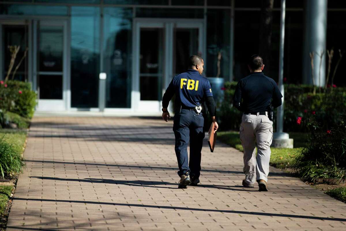 A man wearing an FBI shirt enters Houston ISD headquarters in February, when federal agents raided the office and home of former chief operating officer Brian Busby. Prosecutors allege that Busby engaged in a kickback scheme with a vendor that overbilled the district by $6 million for work it did not perform.