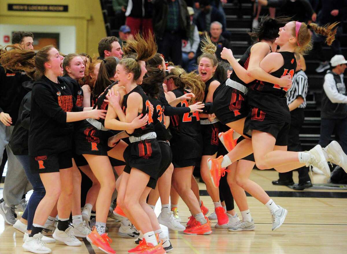 Ridgefield celebrates at the end of its double-overtime win over Staples in the FCIAC girls basketball championship game.
