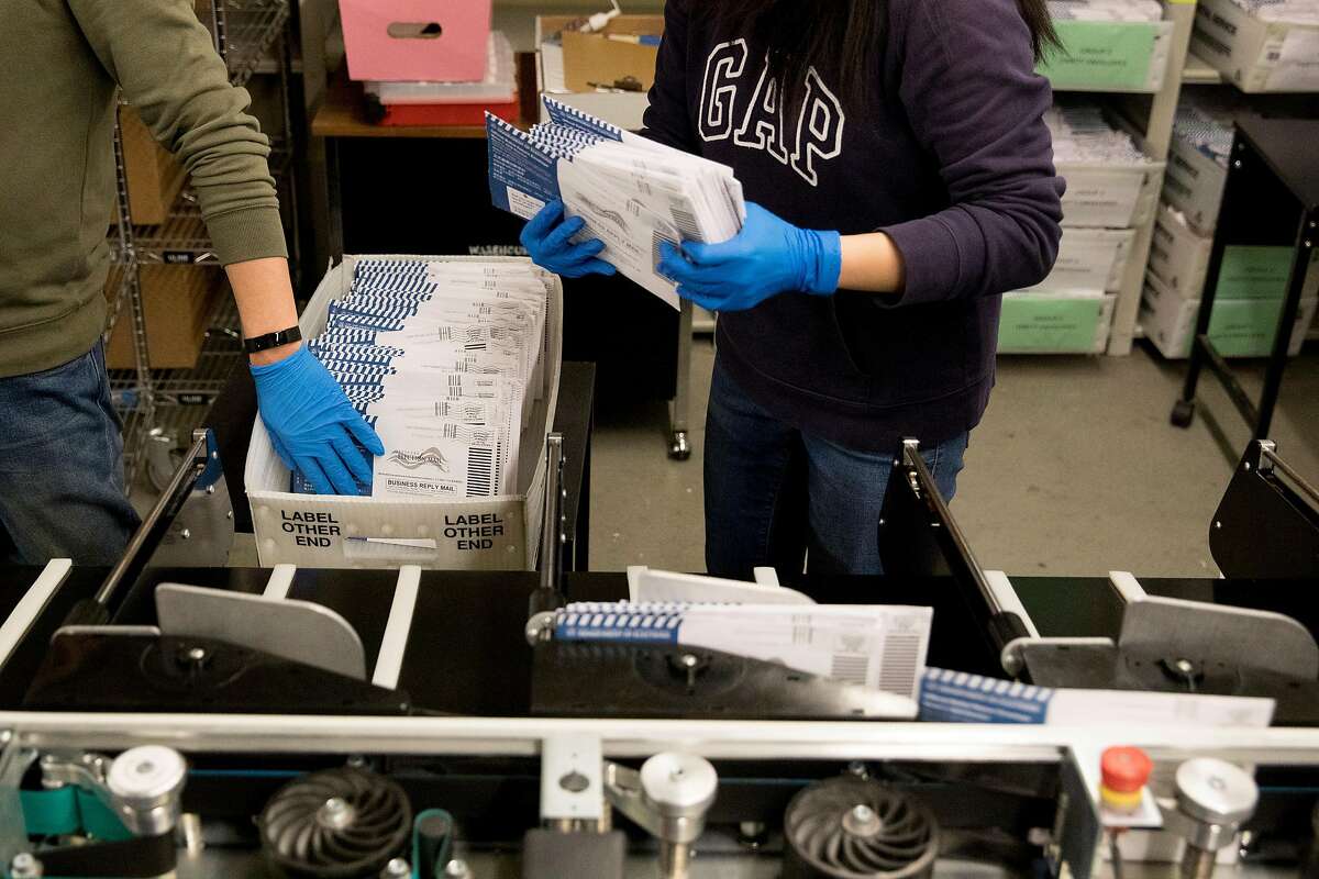 Election staff member Chris Try (left) and Alice Law work to sort out vote-by-mail ballots ahead of the March 3rd election at San Francisco City Hall in San Francisco, Calif. Friday, February 28, 2020.
