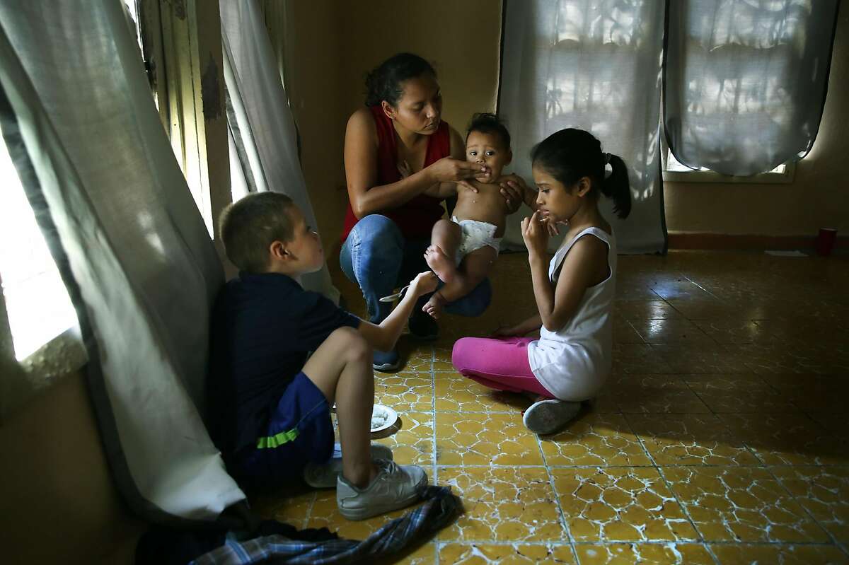 Mariluz Calderon, mother of 4 kids, from Nicaragua, feeds her youngest, Braulio, from a plate of rice in the Good Samaritan Shelter in Nuevo Laredo. Migrants from Central America and Cuba go to asylum hearings in Laredo, Texas, on Thursday, Sept. 19, 2019.