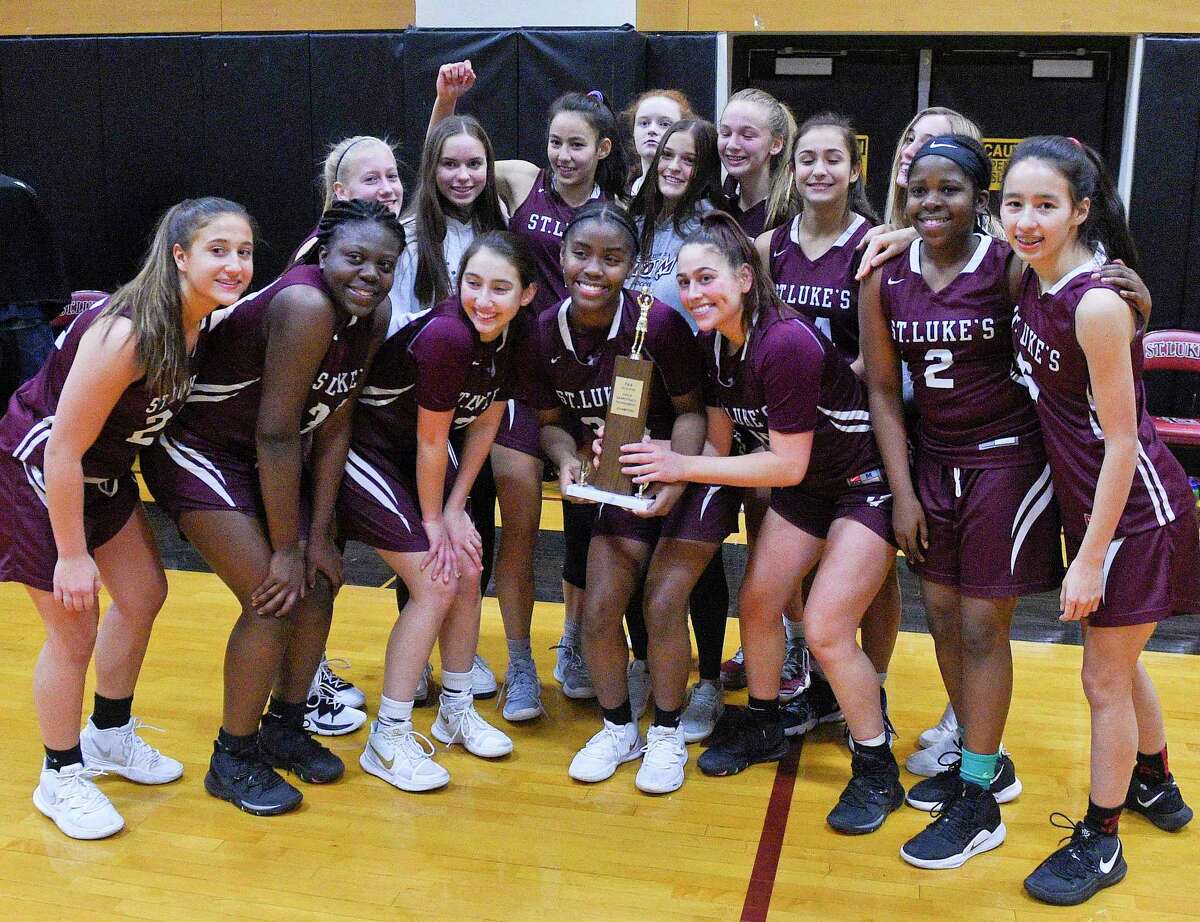 St. Luke's celebrates with the trophy following the Lady Storms 76-55 win against Green Farms Academy in the FAA girls basketball final in New Canaan, Conn., Friday, Feb. 28, 2020.