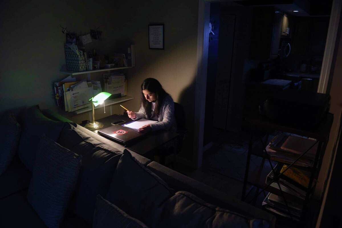 Subhadra Pesantez, 13, does homework at a desk in the living-room. Gabriela Ramon's daughters Subhadra and Cristina Pesantez, 16, have gone to AIS for elementary school and Westside Middle School Academy, both magnet schools. Ramon has helped others with the lottery process. Friday, February 28, 2020, in Danbury, Conn.