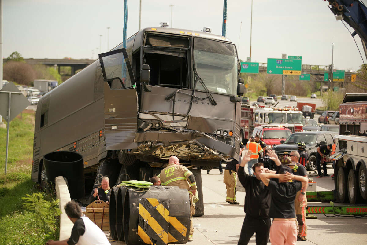 Houston Fire Department and tow truck operators work to safely lift a bus that. Dashed into a barrier off of the barriers along the westbound lanes of the North 610 Loop near Airline, Saturday, Feb. 29, 2020, in Houston. Five out of the eleven passengers aboard were transported to the hospital.