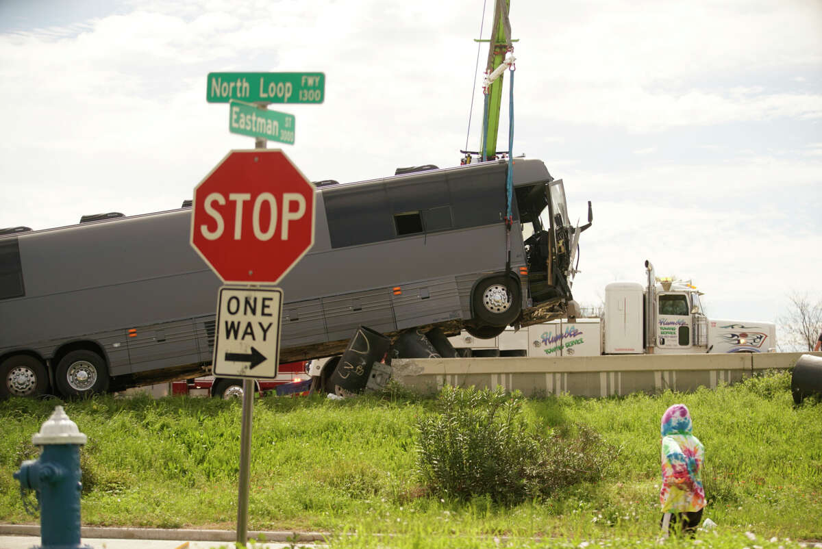 Houston Fire Department and tow truck operators work to safely lift a bus that. Dashed into a barrier off of the barriers along the westbound lanes of the North 610 Loop near Airline, Saturday, Feb. 29, 2020, in Houston. Five out of the eleven passengers aboard were transported to the hospital.