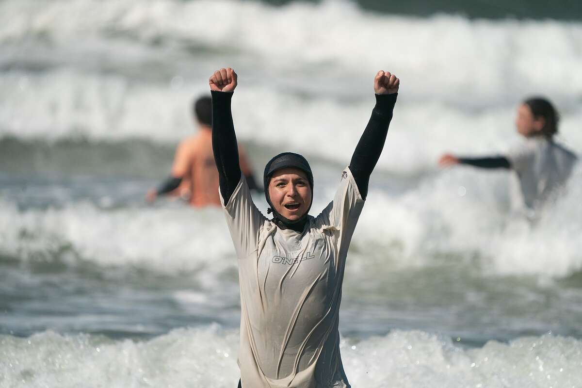 Presidential candidate Tulsi Gabbard helping City Surf Project youths surf at Linda Mar Beach on Saturday, Feb. 29, 2020, in Pacifica , Calif.