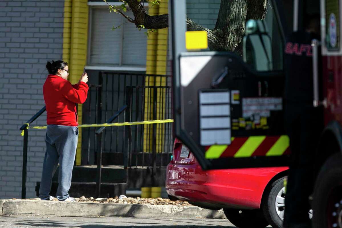 A woman takes a photo of the charred remains of an Altitude Apartment Homes building on the 5200 block of Fredericksburg Road in San Antonio, Texas, on Feb. 29, 2020. A fire broke out in the apartment complex late Friday night as more than 30 units responding to the blaze, resulting in the total loss of a building.