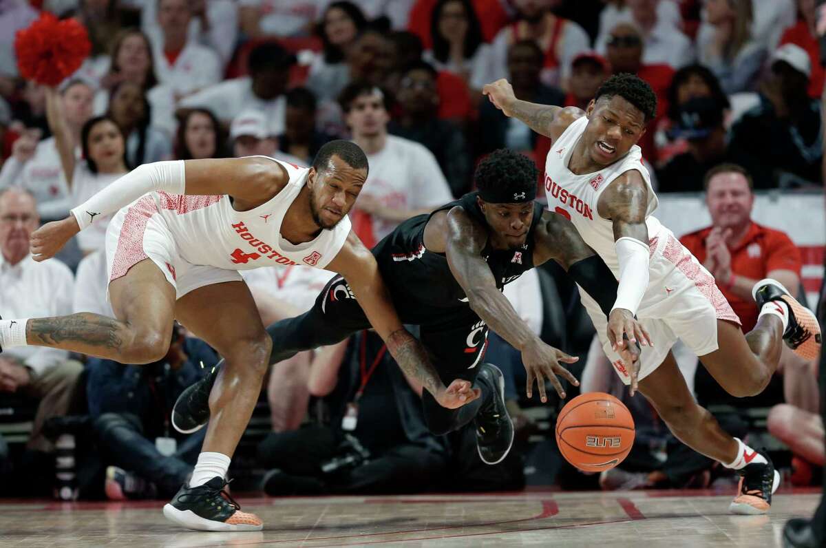 Cincinnati forward Tre Scott, center, Houston forward Justin Gorham, left, and guard Marcus Sasser, right, chase loose ball during the first half of an NCAA college basketball game, Sunday, March 1, 2020, in Houston.