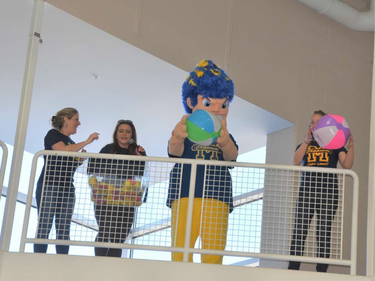Youth gathered at Manistee High School with their families Saturday for a chance to be active, win prizes and enjoy games during the ATP Carnival. Here, a group of staff and the district mascot Chip toss prizes over the railing above the gymnasium to students who had outstretched arms trying to collect the prizes.