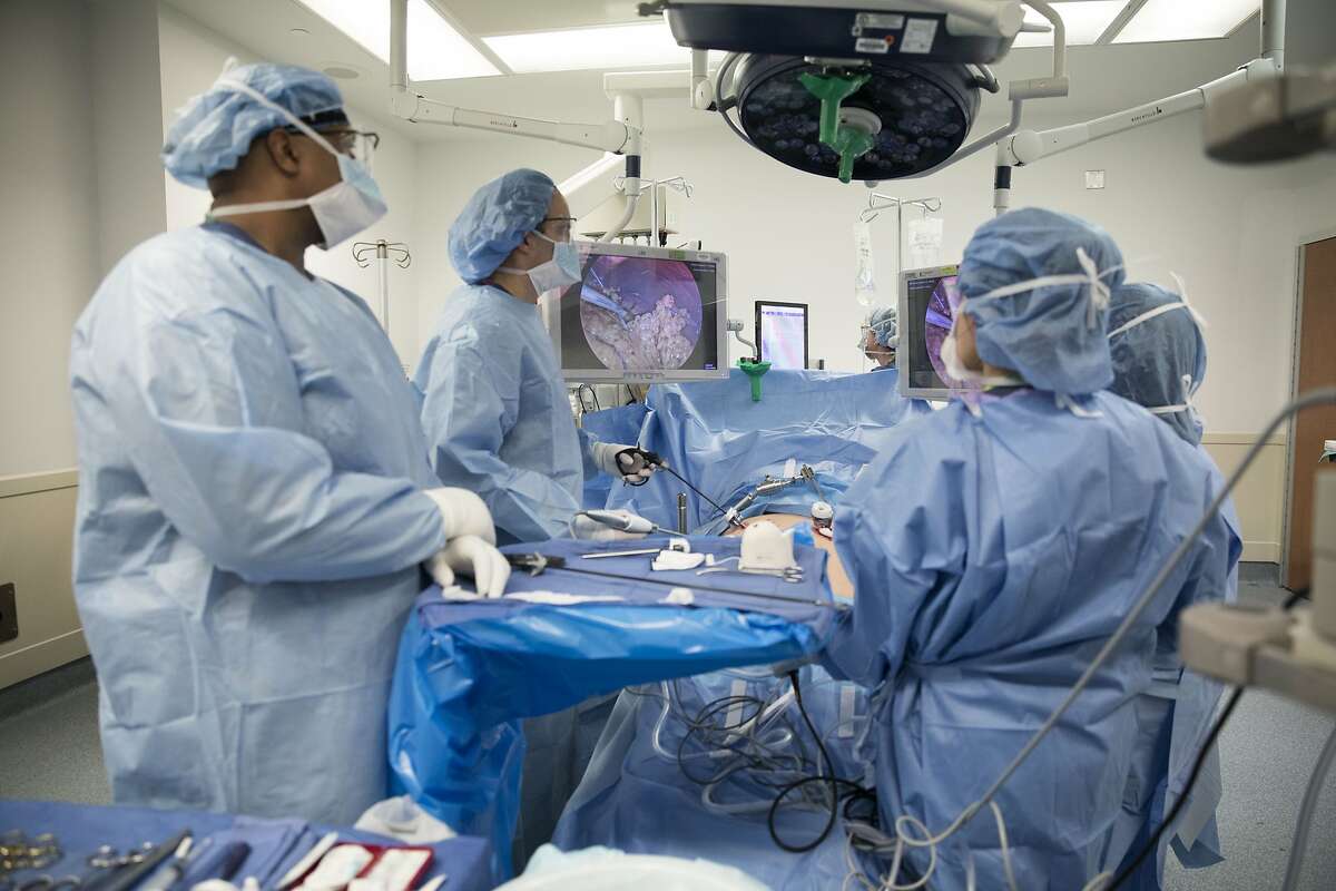 In this Monday, Dec. 16, 2019 photo, Dr. Neil Floch, second from left, performs gastric bypass surgery laparoscopically, using monitors to guide him at Nuvance Health's hospital in Norwalk, Conn. Obesity surgery is becoming a more common way to lose weight, and so is the likelihood of patients getting a second surgery. In 2019, an estimated 15% of all obesity surgeries in the U.S. came after a previous procedure, up from 6% in 2011, according to a surgeons' group. (AP Photo/Kathy Young)
