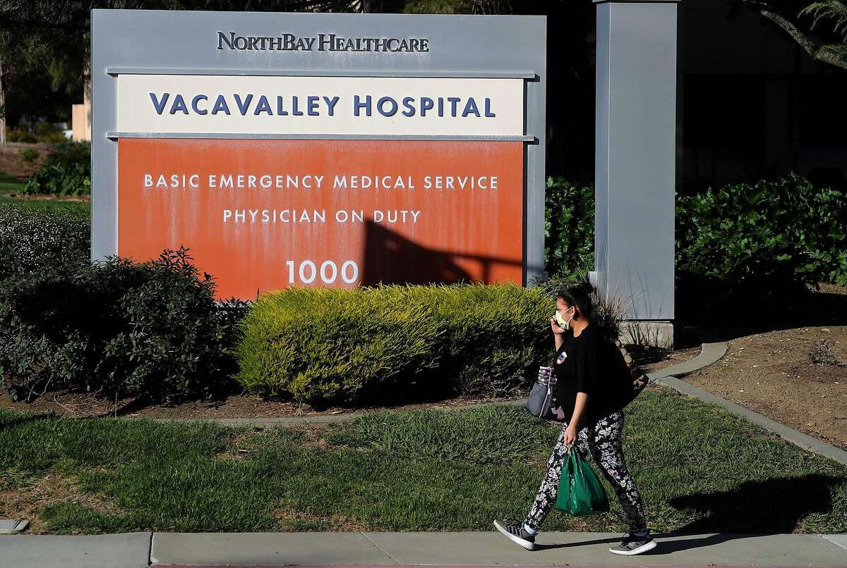 A pedestrian wears a surgical mask as she walks by the VacaValley Hospital on Feb. 27, 2020 in Vacaville, Calif. A Solano County resident now being treated for the coronavirus at UC Davis Medical Center was previously admitted to the Vacaville hospital but was not tested for the virus, officials said. (Justin Sullivan/Getty Images/TNS)