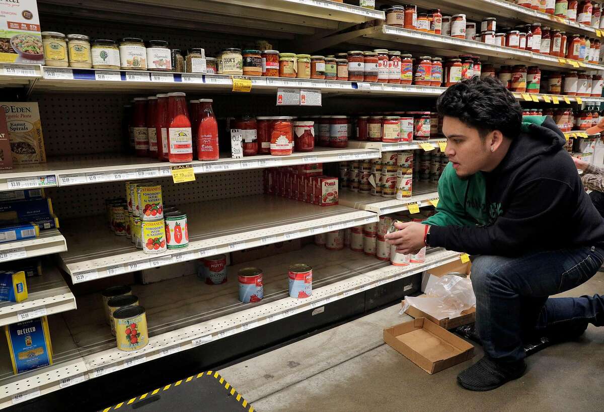 Zach Celso restocks shelves in the canned good section at Rainbow Grocery where customers stocked up on supplies as worries over the Covid-19 virus continued in San Francisco, Calif., on Sunday, March 1, 2020. Stores around the Bay Area are seeing some items sell out like canned goods and hand sanitizer and dry goods that can last longer in people’s homes.