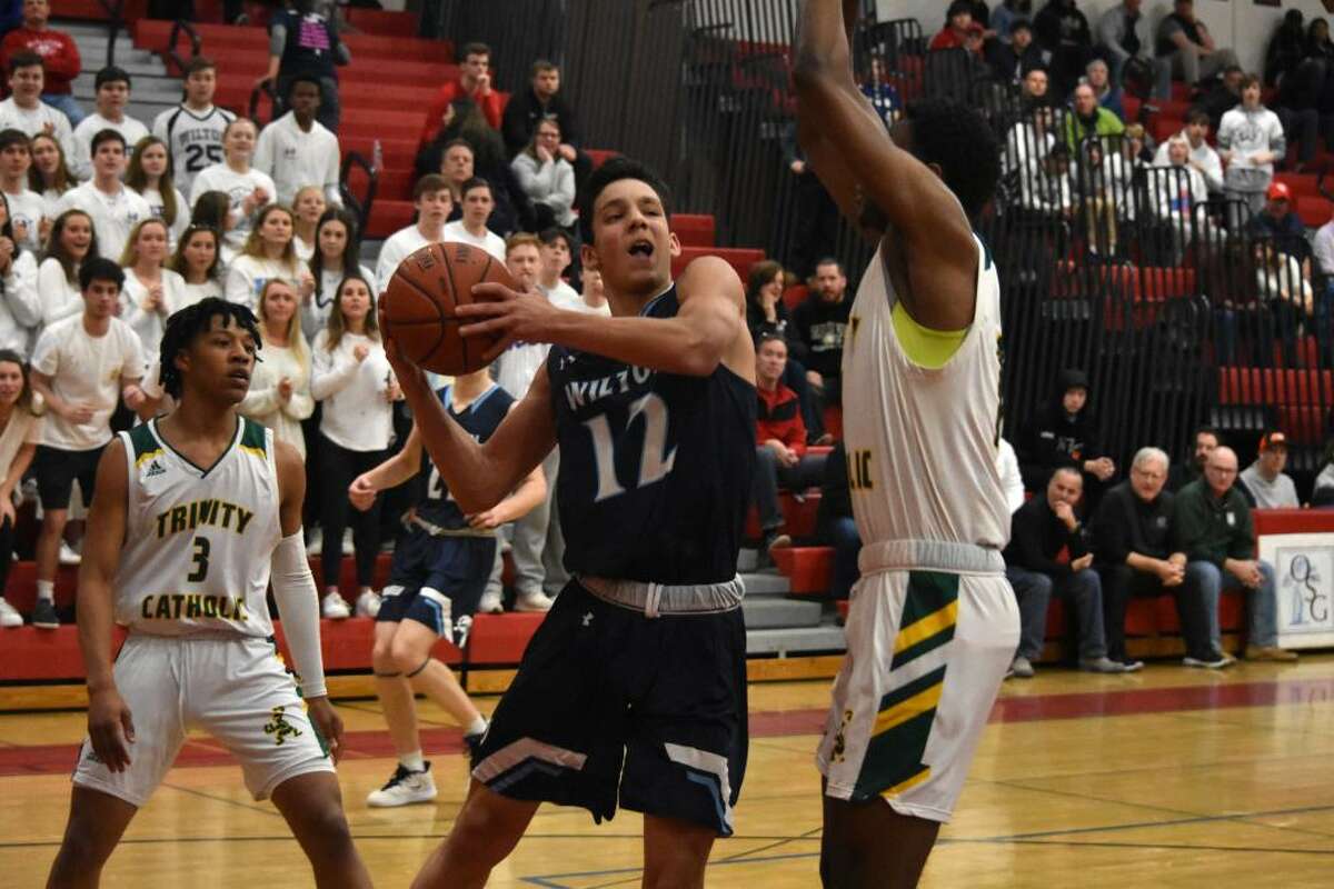 Wilton's Parker Woodring drives to the basket during the FCIAC quarterfinals against Trinity Catholic at Fairfield Warde on Saturday.