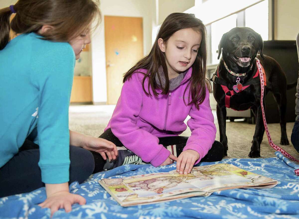 Gabby, 7, and Olivia, 9, Baxendale of Wilton read “Annie and the Wild Animals” to Pepper, a rescue therapy dog from ROAR, at The Wilton Library on Saturday as part of the Tales for Tails program. Gabby, 7, and Olivia, 9, Baxendale of Wilton read â€?“Annie and the Wild Animals†to Pepper, a rescue therapy dog from ROAR, at The Wilton Library on Saturday as part of the Tales for Tails program.