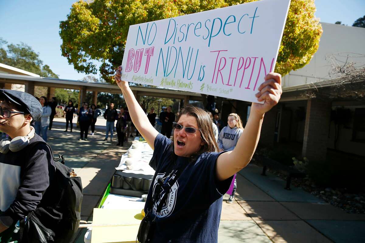 Claudia Akel, Notre Dame de Namur University junior, cheers with others as she holds a sign while attending the rally to save Notre Dame de Namur University in the NDNU quad on Monday, March 2, 2020 in Belmont, Calif.