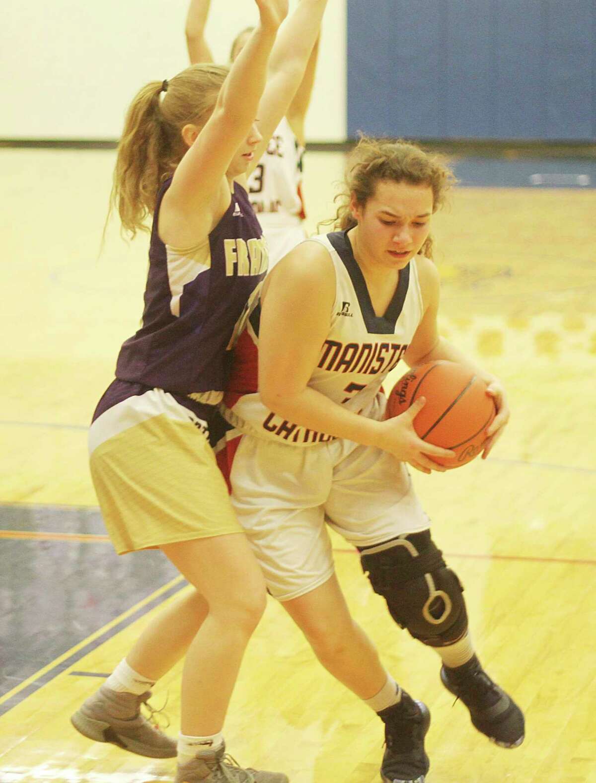 Manistee Catholic Central's Leah Stickney is guarded by a Frankfort defender during the Sabers' district loss in Onekama on Monday. (Kyle Kotecki/News Advocate)