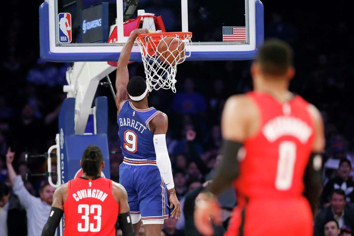 Houston Rockets forward Robert Covington (33) and guard Russell Westbrook (0) watch as New York Knicks guard RJ Barrett (9) dunks during the second quarter of an NBA basketball game in New York, Monday, March 2, 2020. (AP Photo/Kathy Willens)